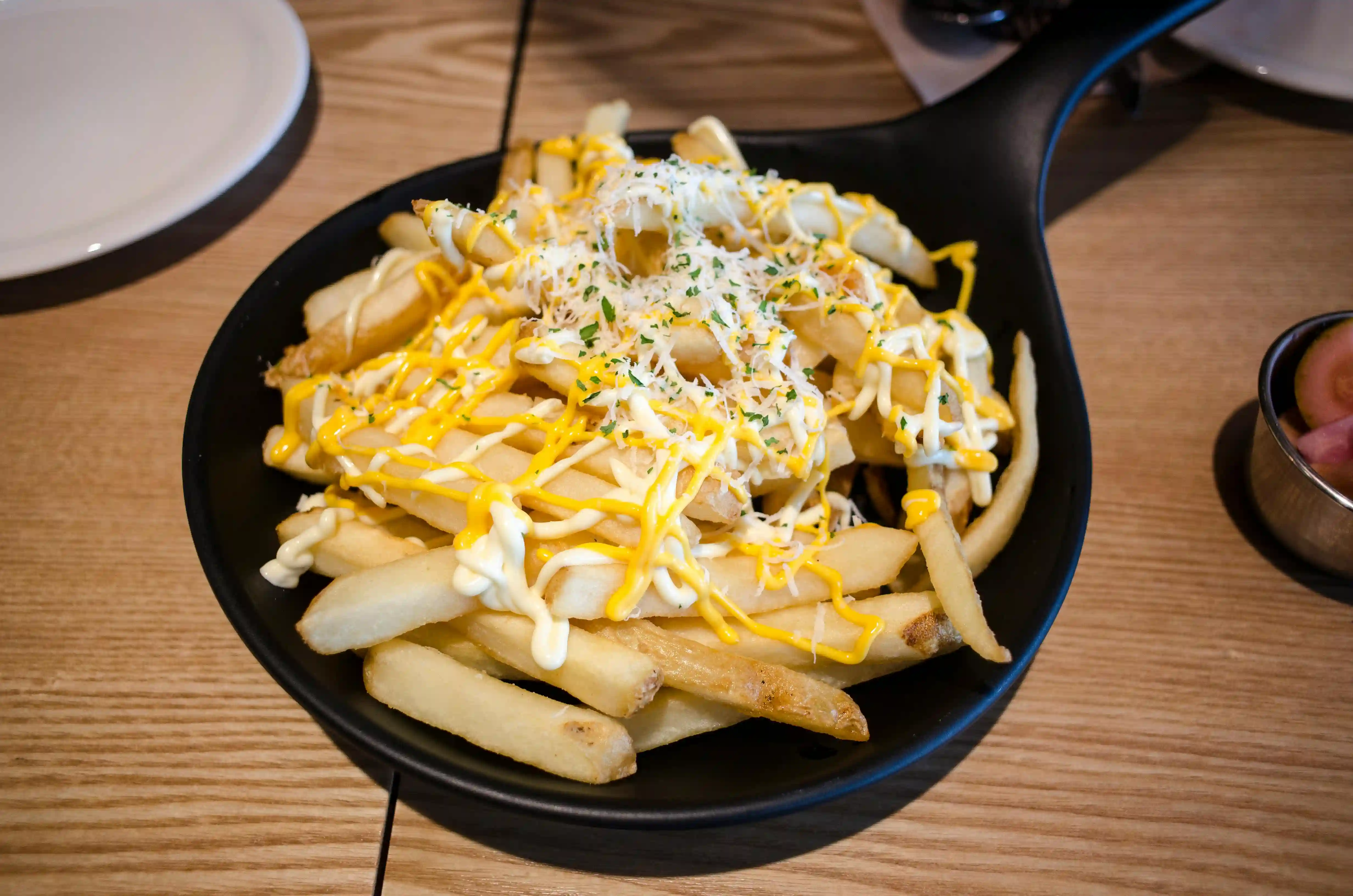 picture of garlic parmesan fries on a black bowl